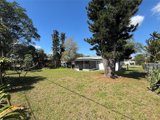 view of yard featuring fence and a sunroom