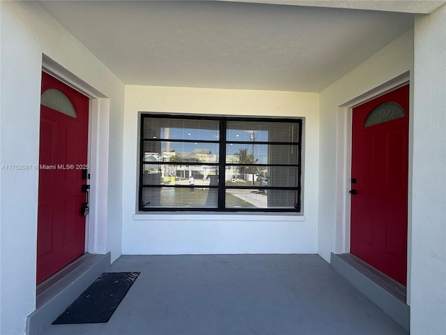 doorway to property featuring stucco siding