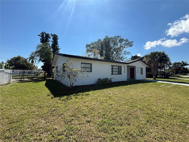 single story home with a front lawn, fence, and stucco siding