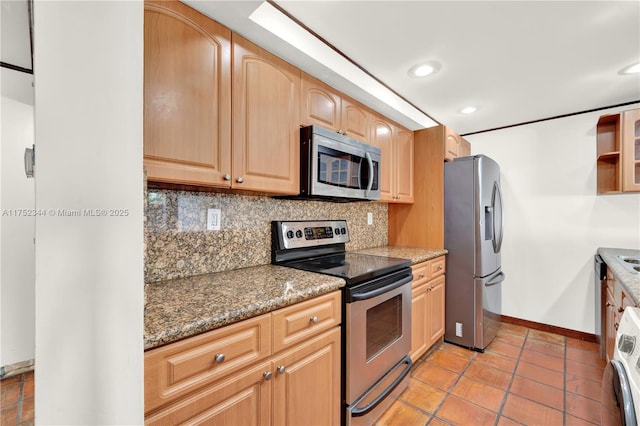 kitchen with light tile patterned floors, washer / clothes dryer, decorative backsplash, appliances with stainless steel finishes, and baseboards