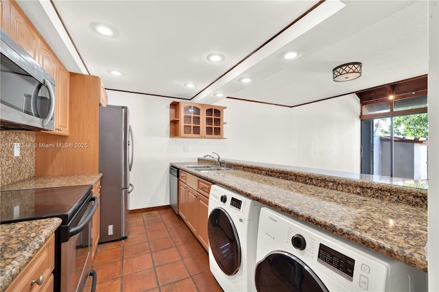 kitchen with tasteful backsplash, recessed lighting, appliances with stainless steel finishes, separate washer and dryer, and dark tile patterned floors