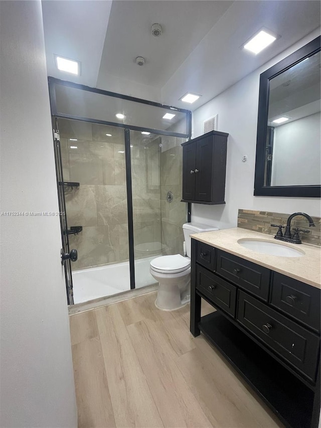 bathroom with wood finished floors, vanity, and toilet