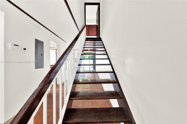 stairway with electric panel and tile patterned floors