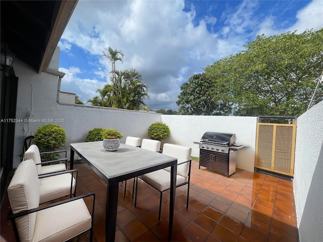 view of patio featuring outdoor dining space, a grill, and fence