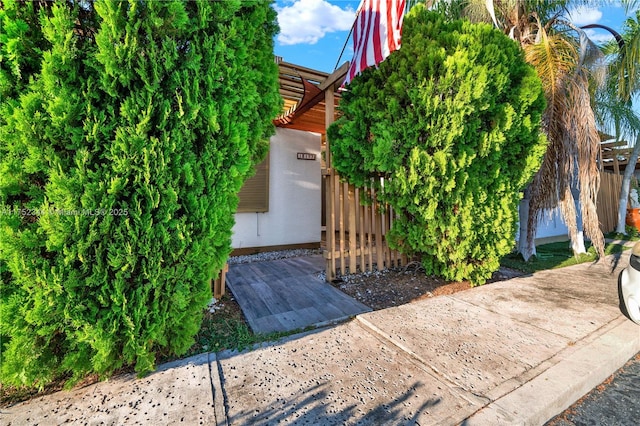 view of side of property with fence and a pergola