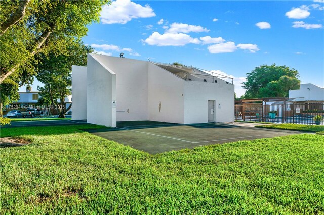 back of property featuring a yard, fence, and stucco siding