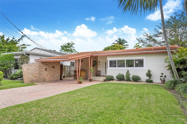 ranch-style home with stucco siding, a tiled roof, and a front yard