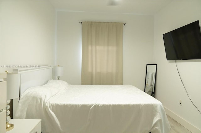 bedroom with light wood finished floors and baseboards