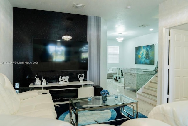 living room featuring stairs, visible vents, and tile patterned floors