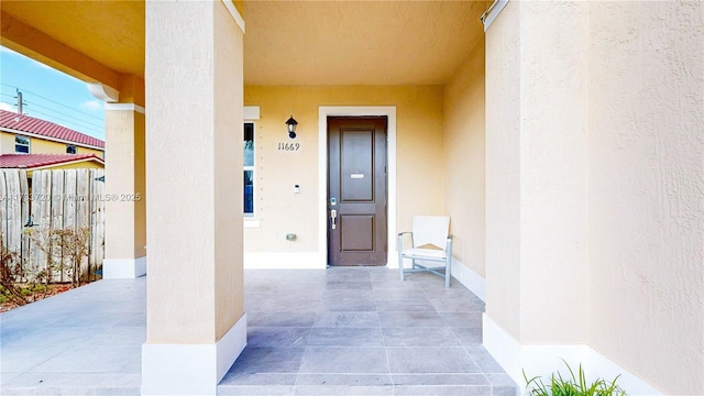 doorway to property with a patio and stucco siding