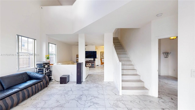 living area with marble finish floor and stairs