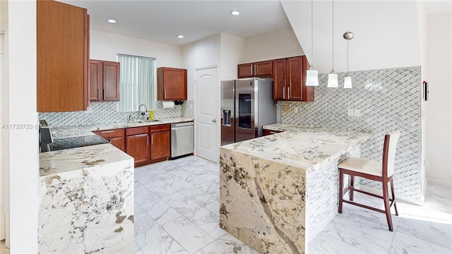 kitchen featuring marble finish floor, light countertops, decorative light fixtures, and stainless steel appliances