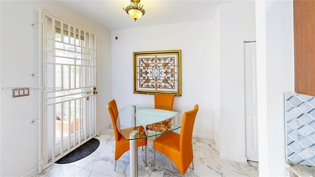 dining room featuring marble finish floor and baseboards