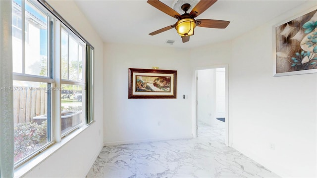 spare room featuring marble finish floor, visible vents, baseboards, and a ceiling fan