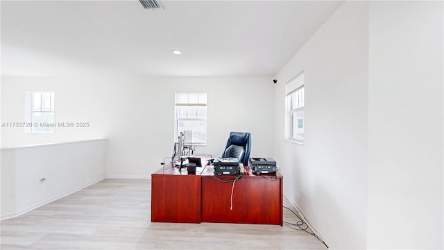 office space with light wood-type flooring, baseboards, and visible vents