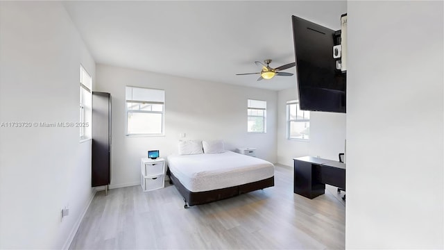 bedroom featuring a ceiling fan, light wood-type flooring, and baseboards