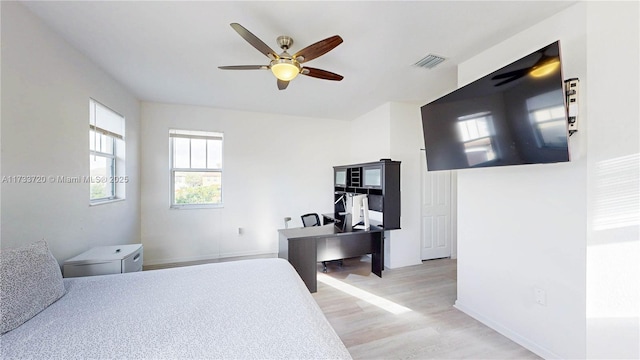 bedroom featuring light wood-type flooring, baseboards, visible vents, and ceiling fan