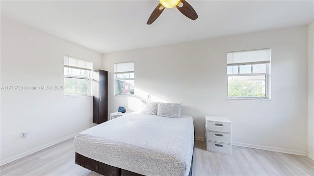 bedroom featuring ceiling fan, light wood-type flooring, and baseboards