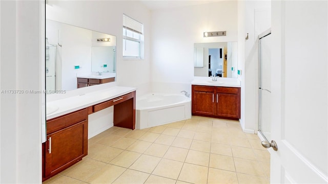 bathroom with a bath, tile patterned flooring, two vanities, and a sink