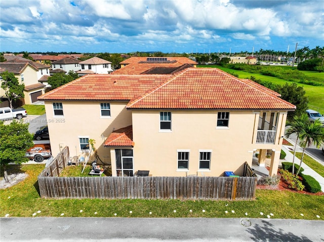 exterior space featuring a tile roof, fence private yard, and stucco siding