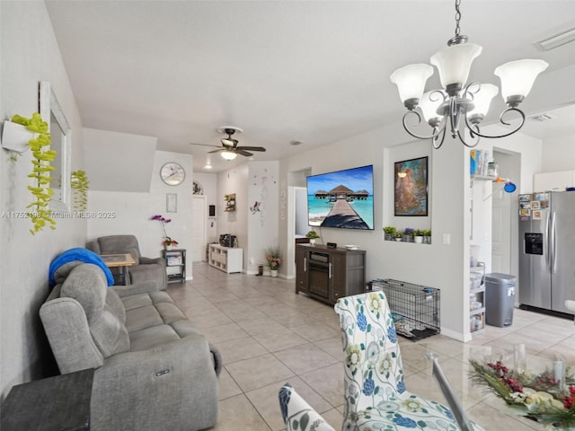 living room with light tile patterned floors, ceiling fan with notable chandelier, visible vents, and baseboards