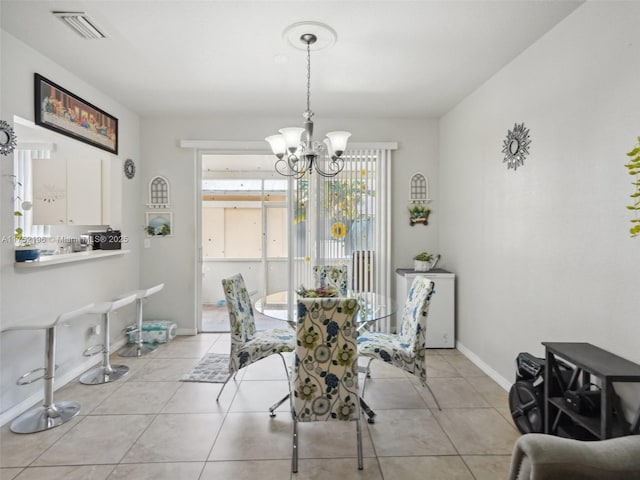 dining room featuring light tile patterned floors, baseboards, visible vents, and a notable chandelier