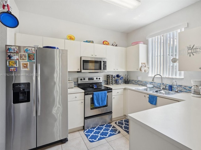 kitchen featuring light countertops, appliances with stainless steel finishes, a sink, and white cabinetry