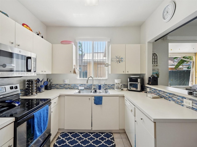 kitchen featuring a sink, stainless steel appliances, light countertops, and white cabinetry