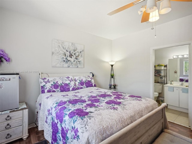 bedroom featuring a sink, ceiling fan, and ensuite bath