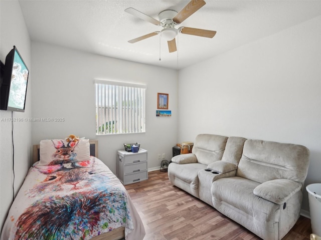 bedroom featuring light wood-type flooring, a ceiling fan, and baseboards