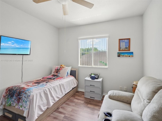 bedroom with light wood-type flooring, baseboards, and a ceiling fan