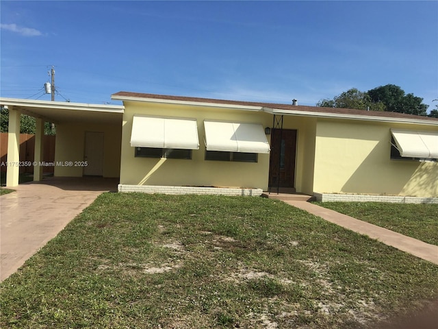 exterior space with an attached carport, stucco siding, and a front yard