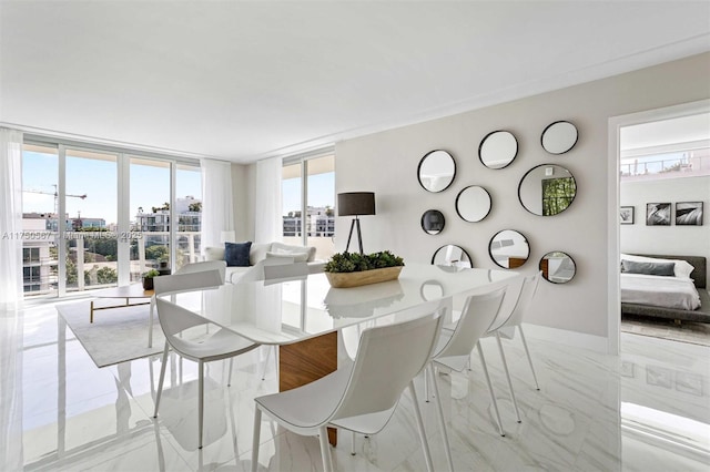 dining area with marble finish floor, a wall of windows, and baseboards