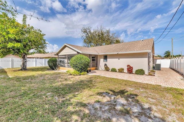 ranch-style house featuring central air condition unit, stucco siding, a fenced backyard, and a front yard