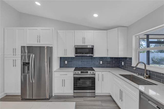 kitchen featuring light countertops, appliances with stainless steel finishes, a sink, and white cabinets