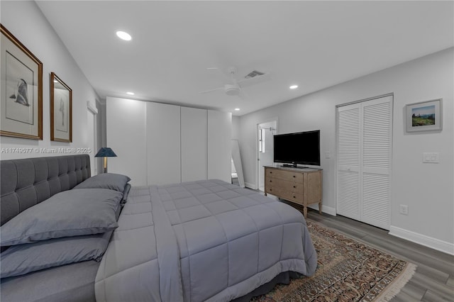 bedroom featuring baseboards, dark wood finished floors, visible vents, and recessed lighting