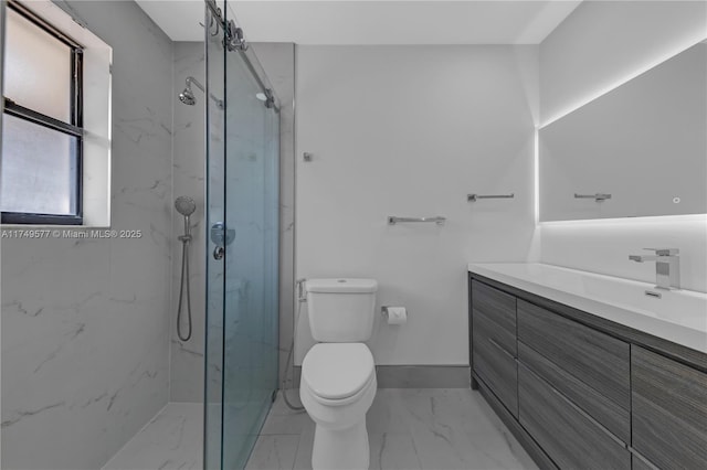 bathroom with a marble finish shower, baseboards, toilet, marble finish floor, and vanity