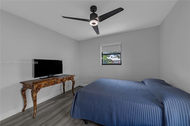 bedroom featuring baseboards, dark wood finished floors, and a ceiling fan