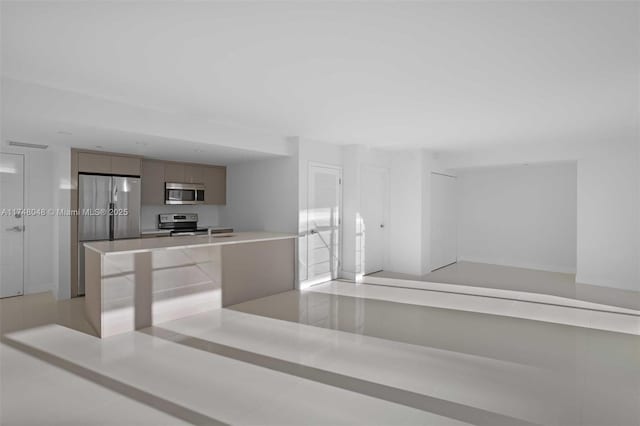 kitchen featuring appliances with stainless steel finishes, light tile patterned flooring, light countertops, and modern cabinets