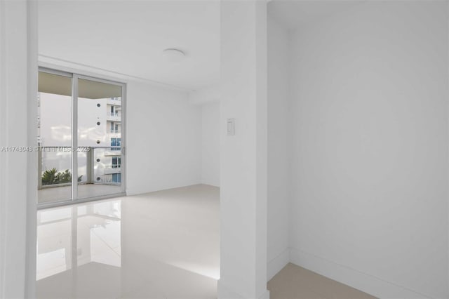 unfurnished room with a wall of windows and tile patterned floors