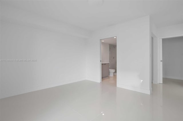 unfurnished room featuring baseboards and tile patterned floors