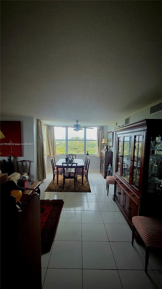 dining space featuring light tile patterned floors, visible vents, and a textured ceiling