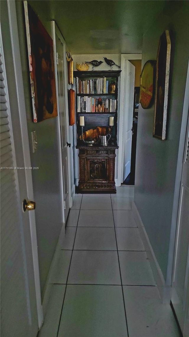 hall with light tile patterned flooring and baseboards