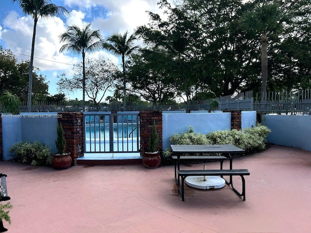 view of patio / terrace featuring fence and a pool