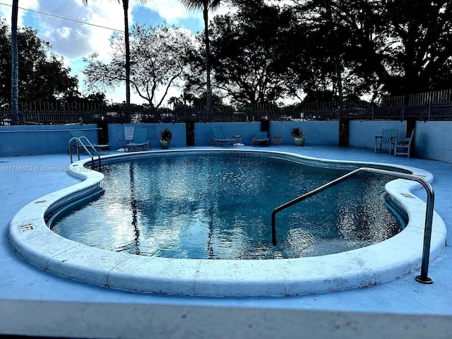 community pool featuring a patio and fence