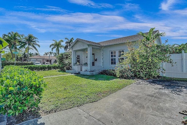 view of front of house with fence and a front lawn
