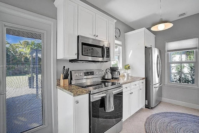 kitchen with stainless steel appliances, dark stone countertops, and white cabinets