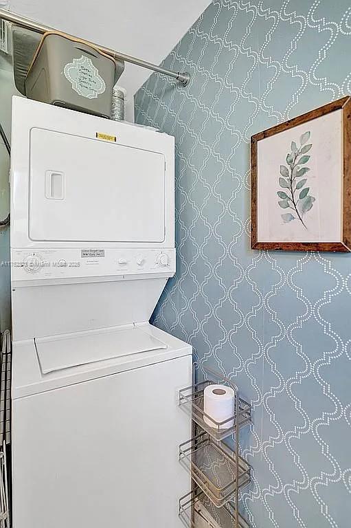clothes washing area featuring laundry area and stacked washer / dryer