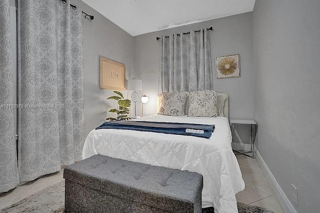 bedroom featuring light tile patterned flooring and baseboards