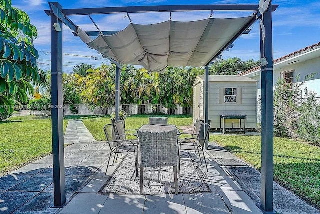view of patio / terrace featuring a fenced backyard, a storage unit, outdoor dining area, and an outdoor structure